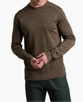 Man wearing a brown long-sleeve shirt and dark pants on a white background
